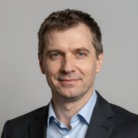 Портрет уверенного российского бизнесмена с дружелюбным взглядом на размытом нейтральном фоне в студии